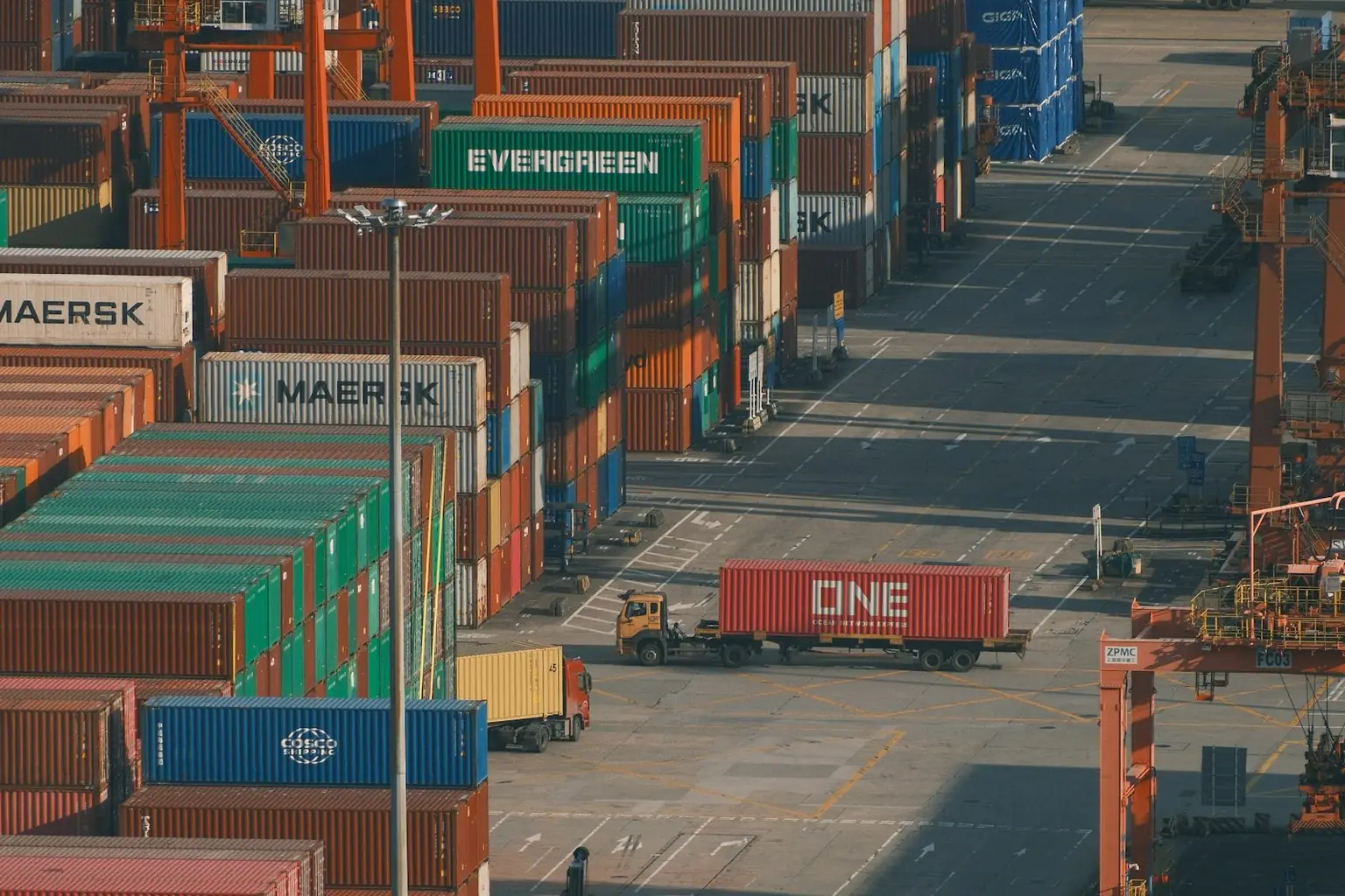 Foto ilustrasi truk membawa kontainer di terminal peti kemas, bukan dokumentasi perusahaan